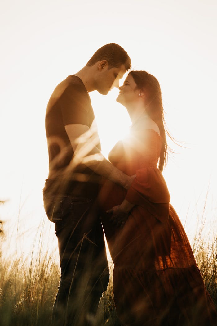 A romantic couple embracing in a sunlit field, symbolizing love and togetherness.